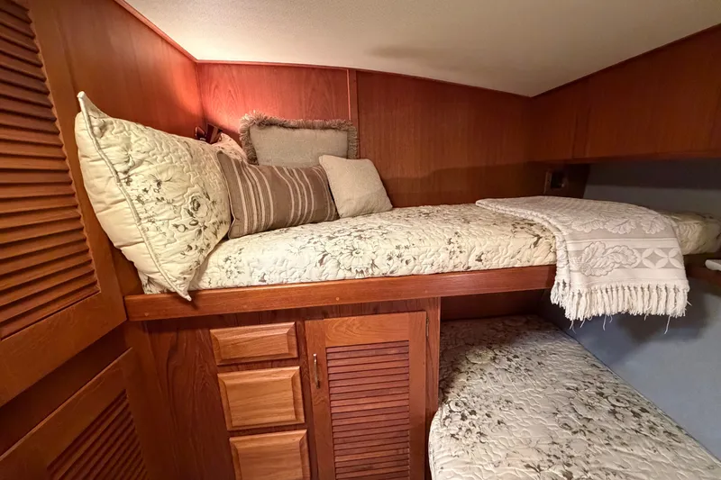 Slide: The Image of Cozy cabin interior of 1986 Viking 48 Motor Yacht with wooden accents and plush bedding. - 30