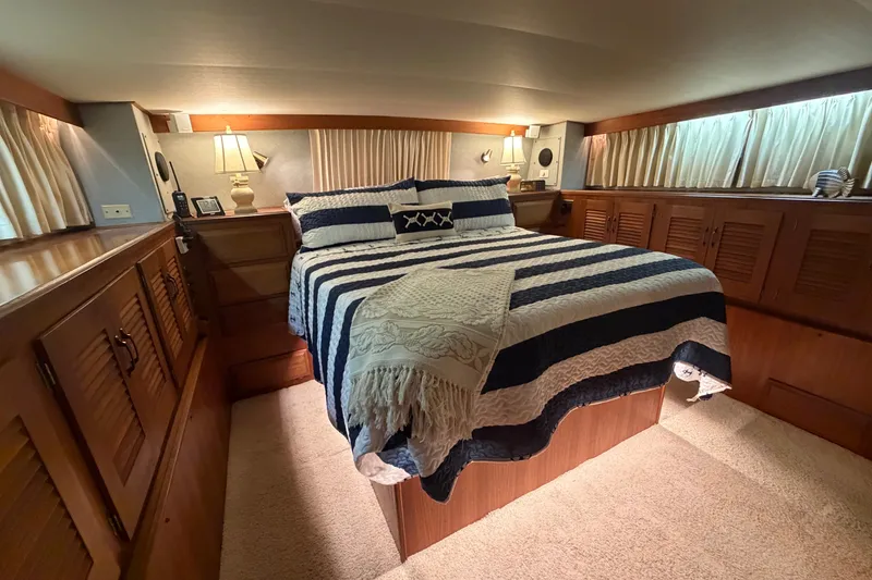Slide: The Image of Luxurious bedroom interior of 1986 Viking 48 Motor Yacht with striped bedding. - 28
