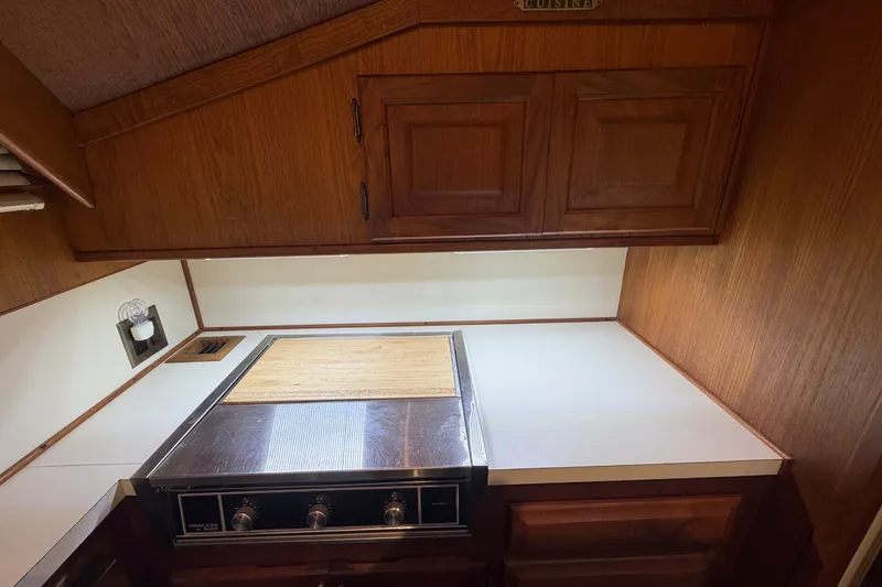 Slide: The Image of 1986 Viking 48 Motor Yacht kitchen with wooden cabinets and stainless steel stove. - 16