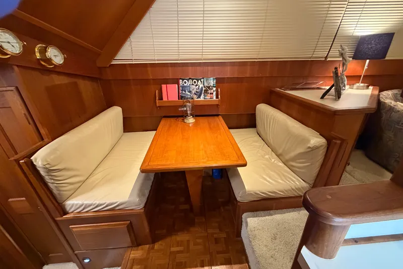 Slide: The Image of Cozy dining area in 1986 Viking 48 Motor Yacht with wood table and cushioned seating. - 19