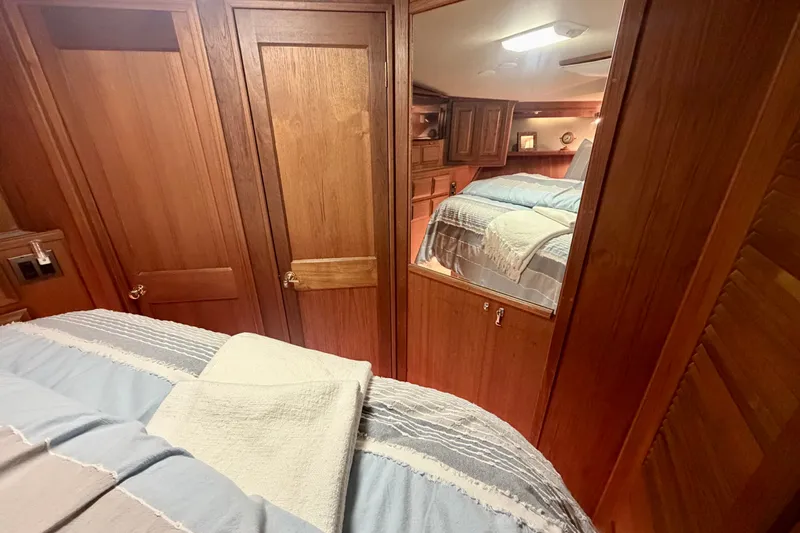 Slide: The Image of Interior of 1986 Viking 48 Motor Yacht with wooden cabinetry and cozy bedding. - 40