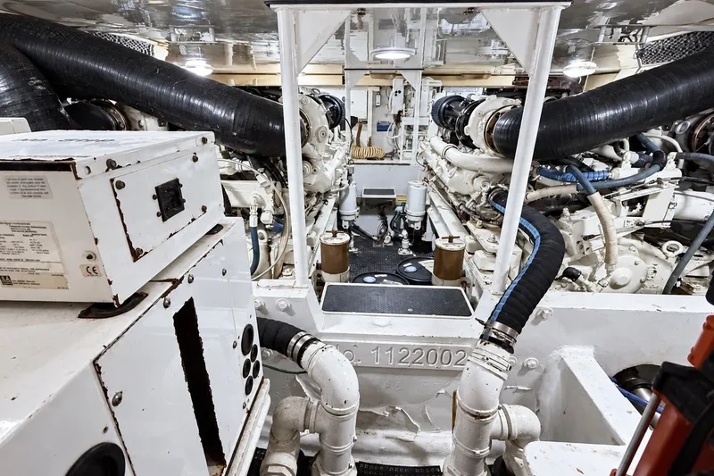Slide: The Image of Engine room of a 2002 Viking 52 Convertible yacht, showcasing machinery and piping. - 65