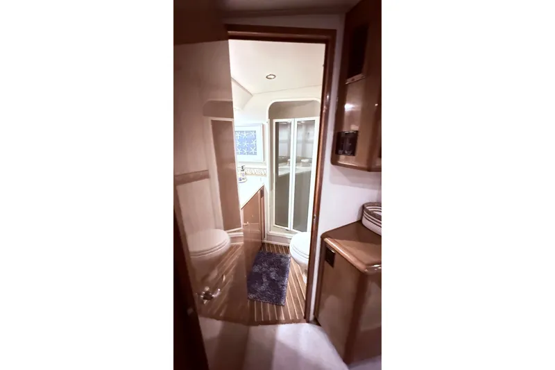 Slide: The Image of Interior view of 2002 Viking 52 Convertible yacht bathroom with shower and wooden accents. - 51