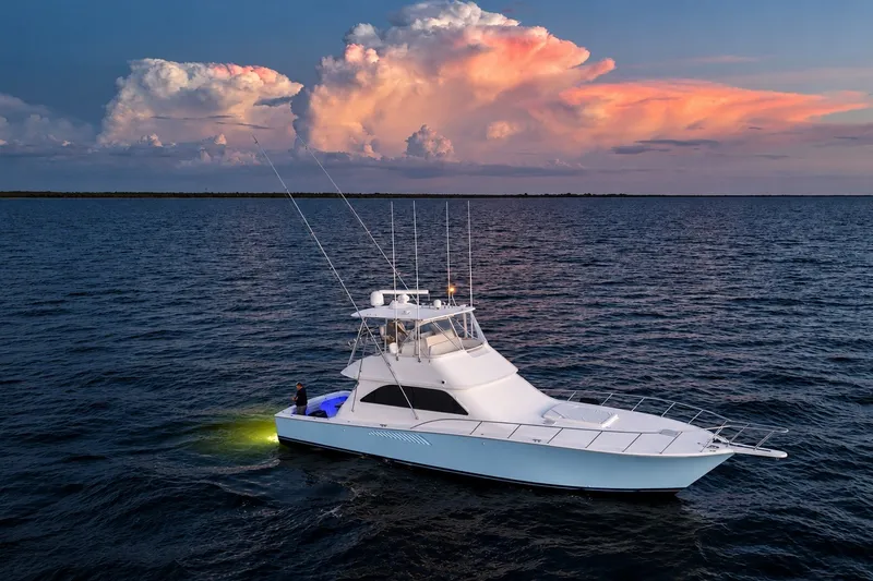 Slide: The Image of 2002 Viking 52 Convertible yacht on open water at sunset. - 11