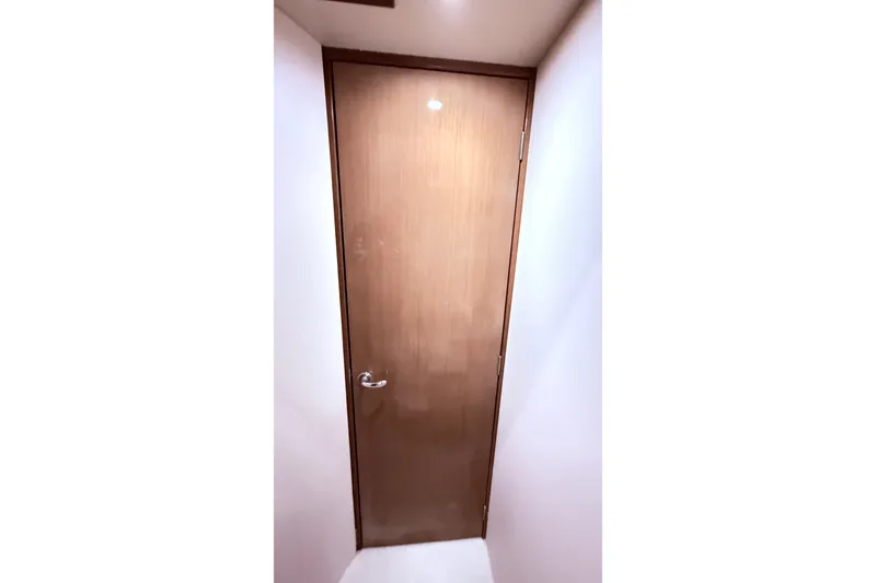 Slide: The Image of Wooden door inside a 2002 Viking 52 Convertible yacht, featuring sleek design and modern handle. - 42