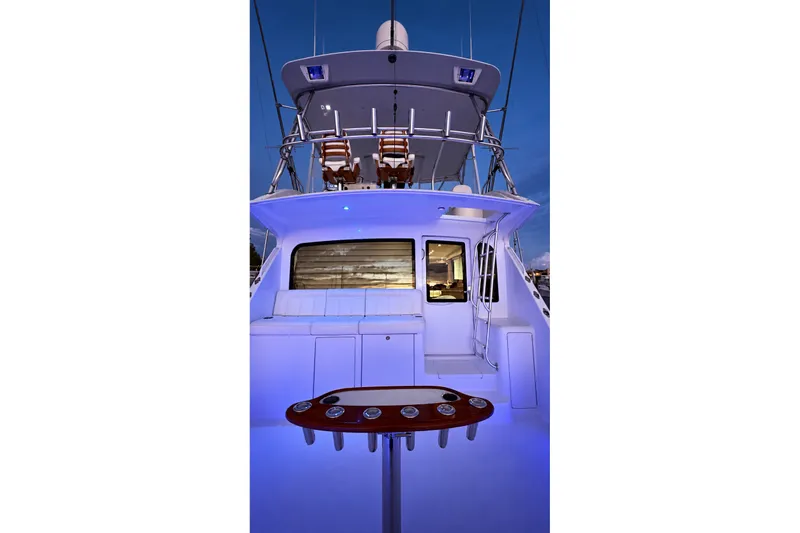 Slide: The Image of 2002 Viking 52 Convertible yacht with illuminated deck and seating area at dusk. - 37
