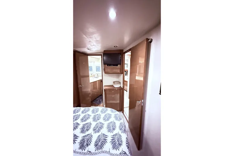 Slide: The Image of Interior of 2002 Viking 52 Convertible yacht with cozy bedroom and wooden cabinetry. - 54