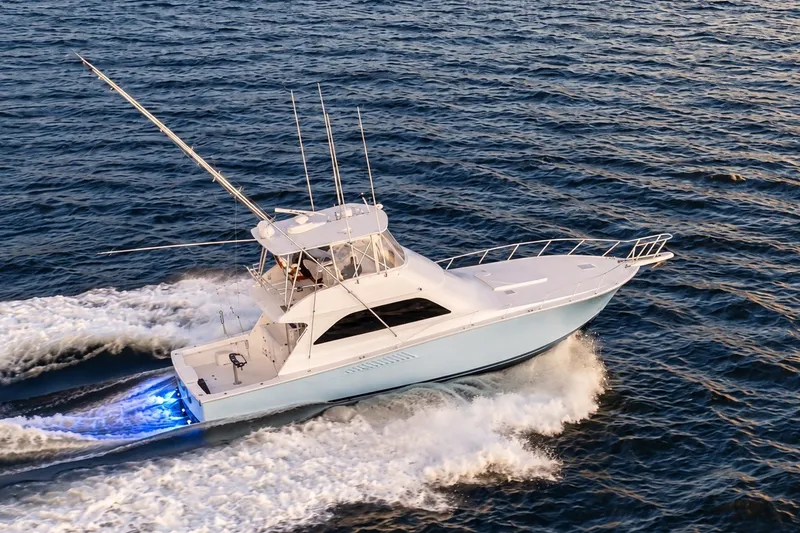 Slide: The Image of 2002 Viking 52 Convertible yacht cruising on open water with blue LED lights. - 3