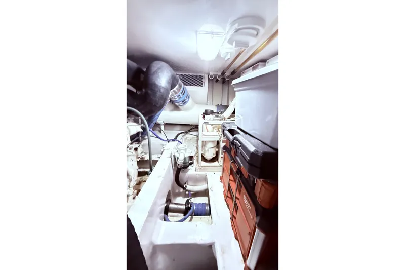Slide: The Image of Engine room of a 2002 Viking 52 Convertible yacht, featuring mechanical components and storage. - 62