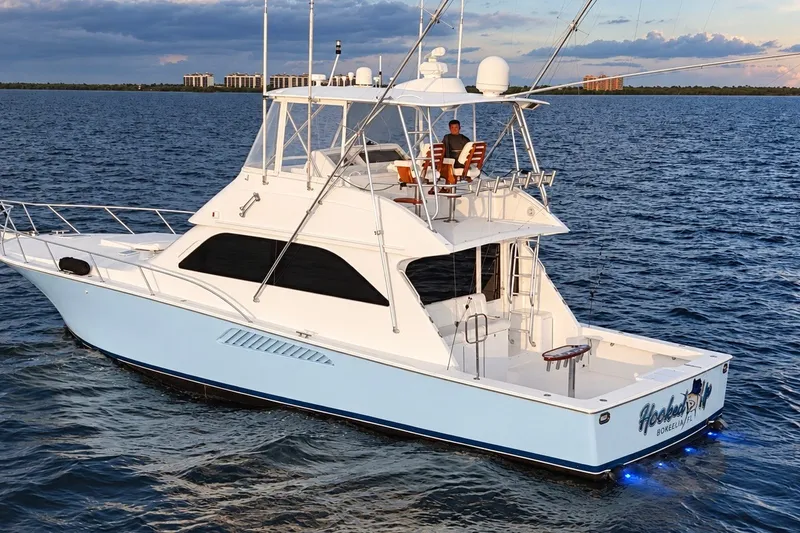 Slide: The Image of 2002 Viking 52 Convertible yacht cruising on open water at sunset. - 17