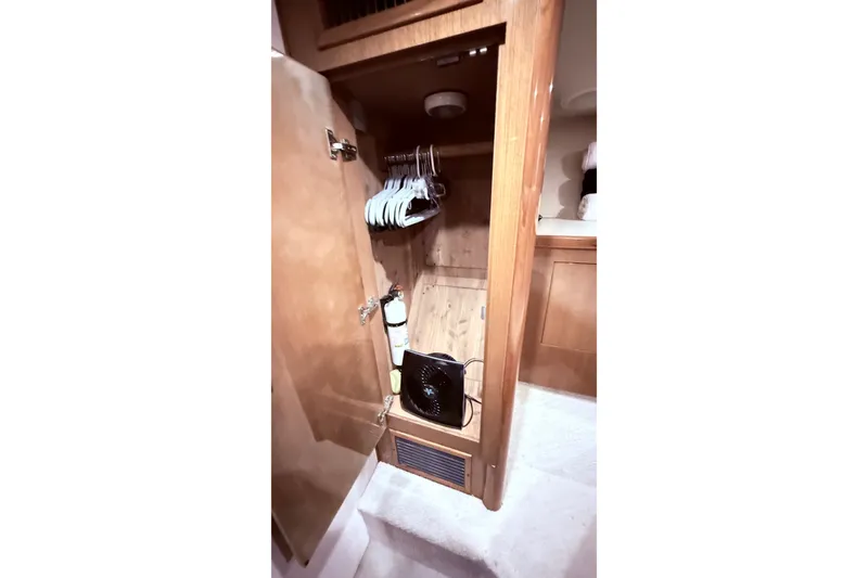 Slide: The Image of Wooden closet interior on a 2002 Viking 52 Convertible yacht with hangers and equipment. - 58