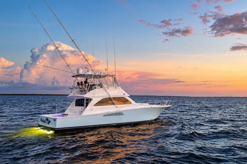 Slide: The Image of 2002 Viking 52 Convertible yacht cruising at sunset on open water. - 4