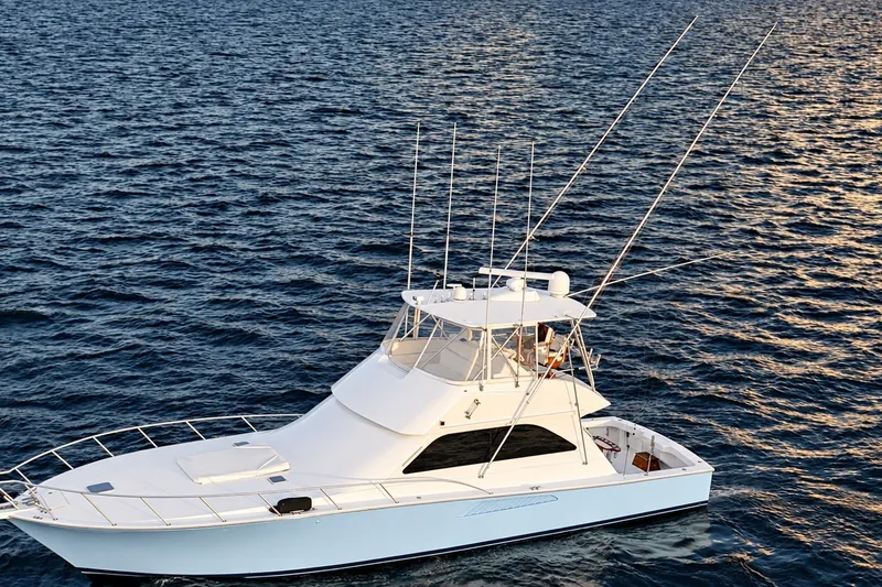 Slide: The Image of 2002 Viking 52 Convertible yacht on open water, showcasing sleek design and fishing equipment. - 16