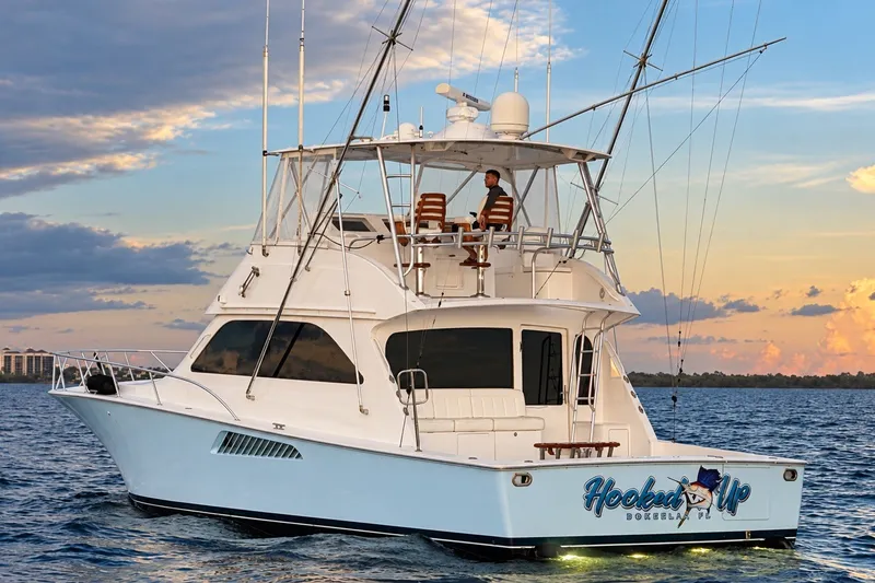 Slide: The Image of 2002 Viking 52 Convertible yacht on water at sunset, featuring "Hooked Up" branding. - 6