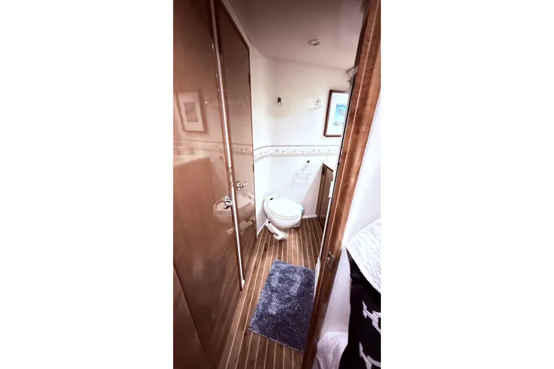 Slide: The Image of Bathroom interior of 2002 Viking 52 Convertible yacht with wooden flooring and modern fixtures. - 50