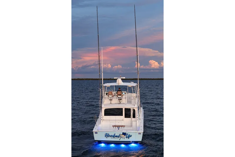 Slide: The Image of 2002 Viking 52 Convertible yacht with blue underwater lights at sunset. - 13
