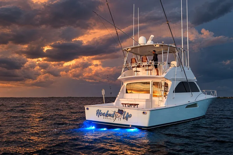 Slide: The Image of 2002 Viking 52 Convertible yacht at sunset with dramatic clouds and ocean backdrop. - 8