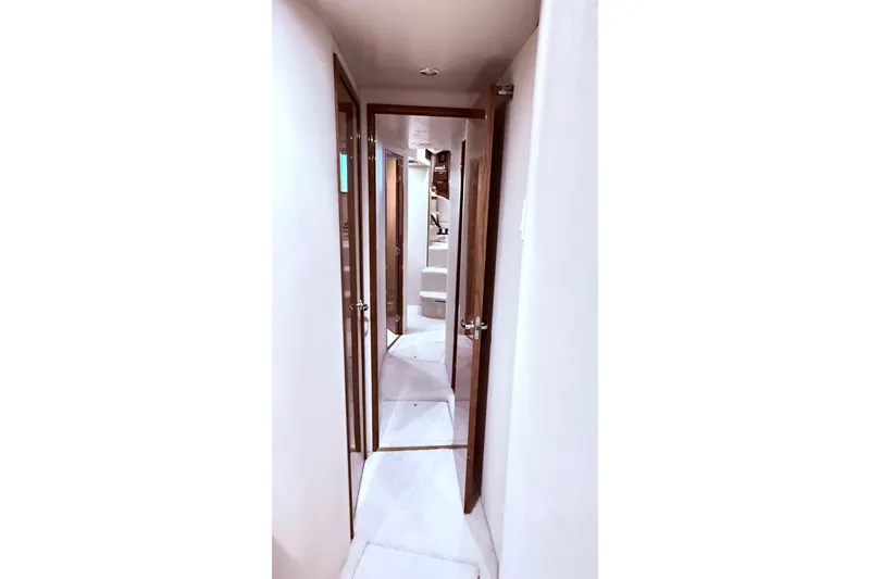 Slide: The Image of Hallway inside 2002 Viking 52 Convertible yacht, featuring wooden doors and carpeted flooring. - 59