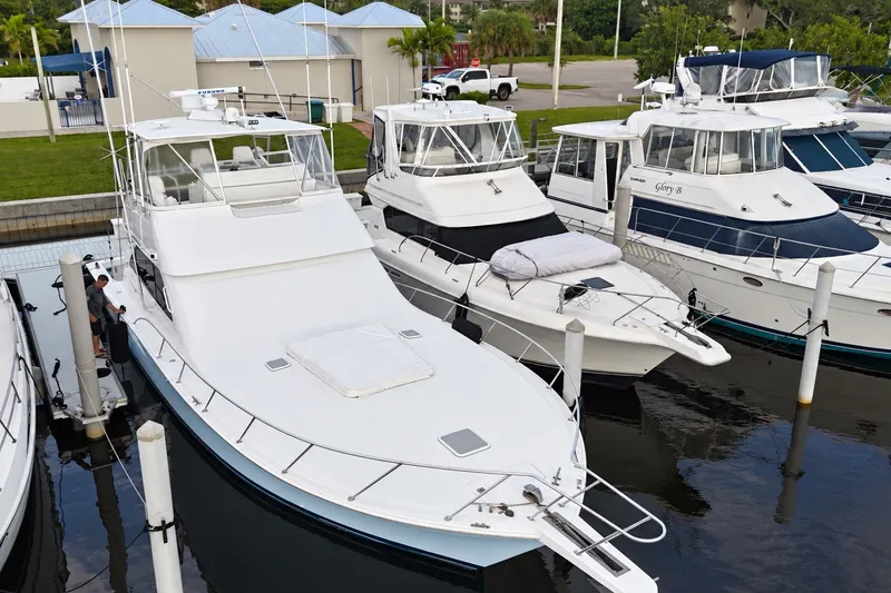 Slide: The Image of 2002 Viking 52 Convertible yacht docked among other boats at a marina. - 30