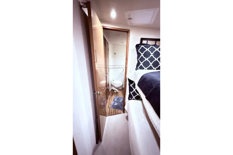 Slide: The Image of Interior of 2002 Viking 52 Convertible yacht showing bedroom and bathroom with modern decor. - 46