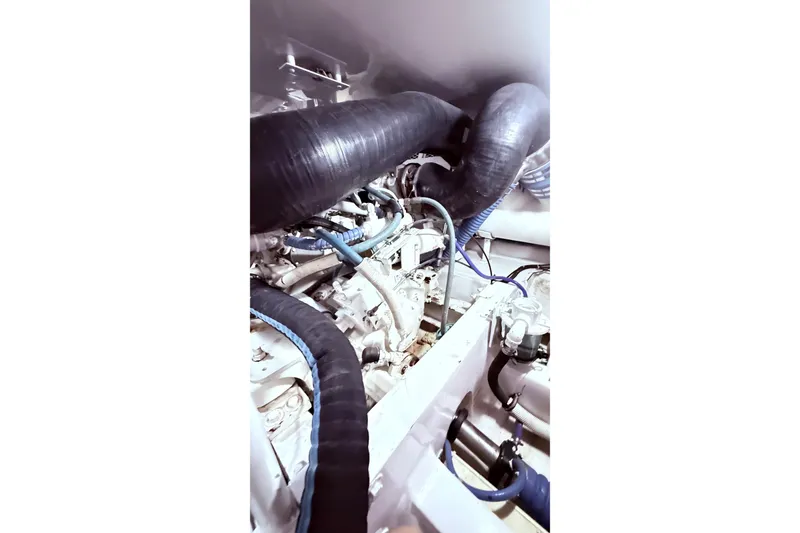Slide: The Image of Engine room of 2002 Viking 52 Convertible yacht with visible hoses and components. - 63
