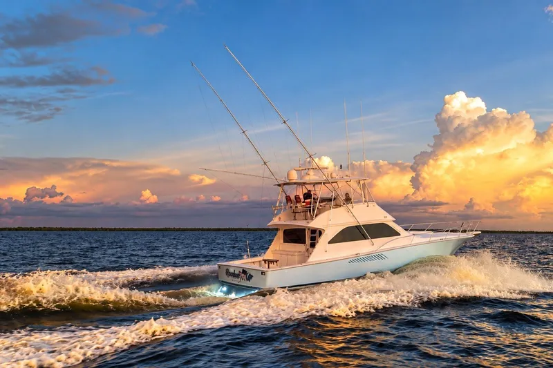Slide: The Image of 2002 Viking 52 Convertible yacht cruising at sunset on open water. - 2