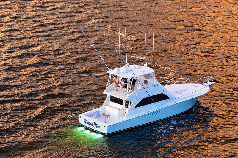 Slide: The Image of 2002 Viking 52 Convertible yacht cruising on open water at sunset. - 18