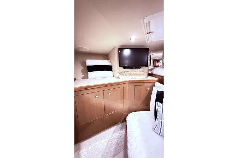 Slide: The Image of Interior of 2002 Viking 52 Convertible yacht with TV, cabinets, and cozy bedding. - 60