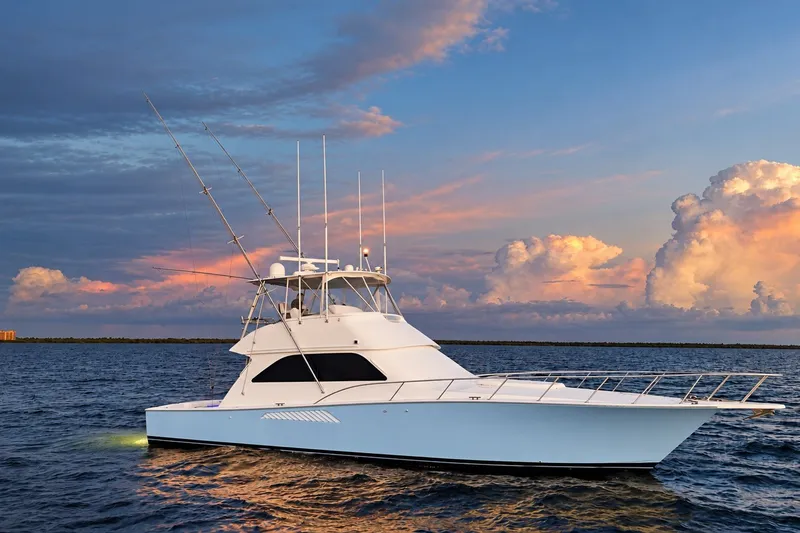 Slide: The Image of 2002 Viking 52 Convertible yacht on serene ocean at sunset. - 24