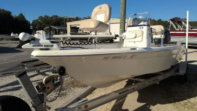 Slide: The Image of A white 2016 NauticStar 214 boat on a trailer in a marina area. - 3