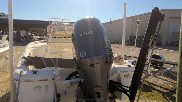 Slide: The Image of A 2016 NauticStar 214 boat with a 150 HP outboard motor, parked on a sunny lot. - 7