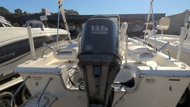 Slide: The Image of A 2004 Sea Pro 1900SV with a 115 HP outboard motor, parked in a boat area. - 5