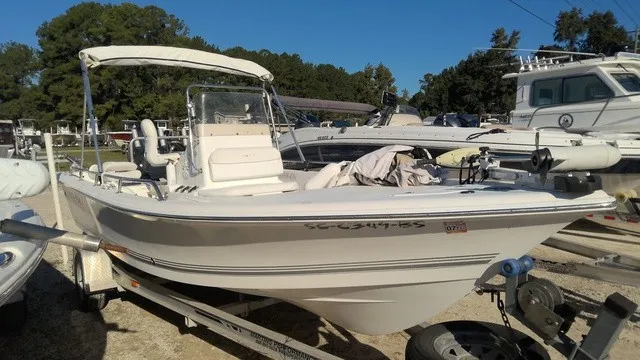 The Image of 2004 Sea Pro 1900SV on a trailer, featuring a Bimini top and clear windshield. - 1
