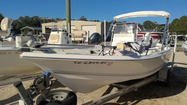 Slide: The Image of A white 2004 Sea Pro 1900SV boat on a trailer in a marina area. - 2