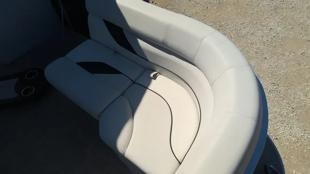 Slide: The Image of A sleek, curved seating sofa in a boat, featuring light gray upholstery with black accents. - 7