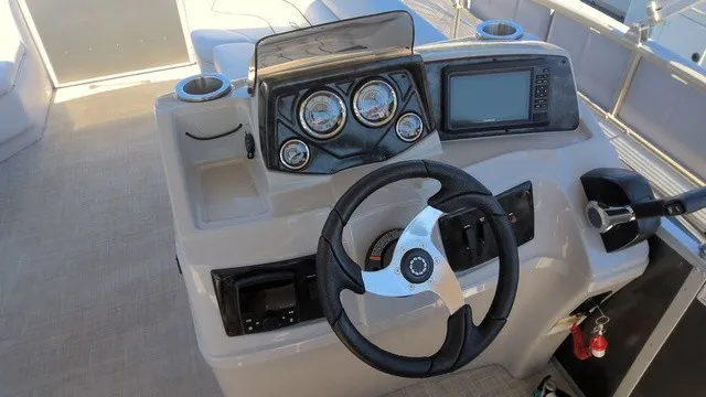 Slide: The Image of The image shows the helm of a SunCatcher Select 20C boat with a steering wheel and gauges. - 8
