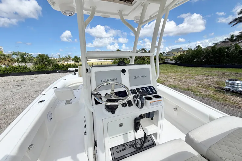 Slide: The Image of 2021 Caymas 28 HB boat cockpit with Garmin navigation, steering wheel, and clear sky background. - 14