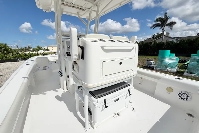 Slide: The Image of 2021 Caymas 28 HB boat interior with seating and storage, under a clear blue sky. - 13