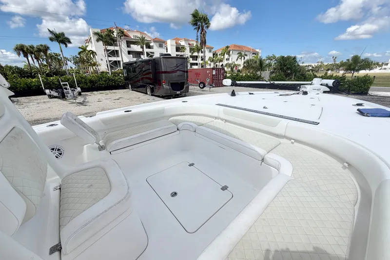 Slide: The Image of 2021 Caymas 28 HB boat interior with white seating and storage, parked outdoors. - 22