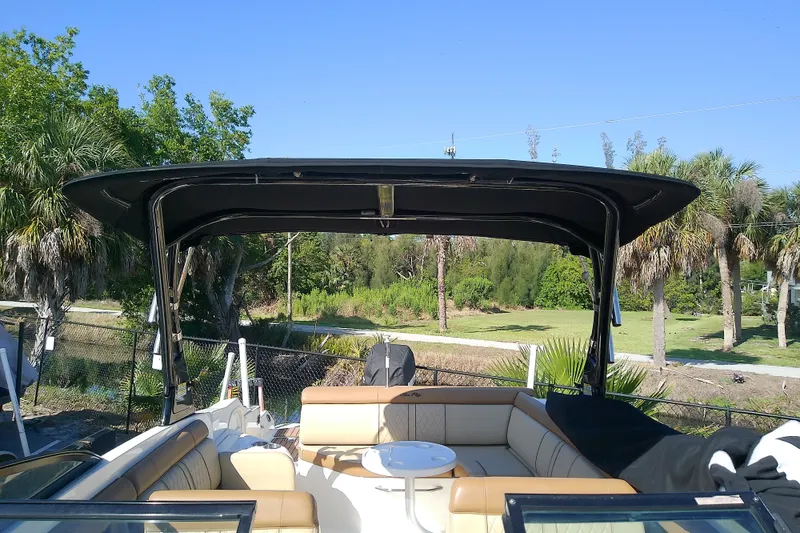 Slide: The Image of 2015 Sea Ray SDX 270 Outboard boat with canopy and seating, surrounded by lush greenery. - 33