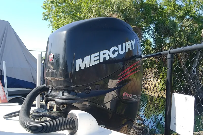 Slide: The Image of Mercury outboard motor on 2015 Sea Ray SDX 270, parked near trees and fence. - 14