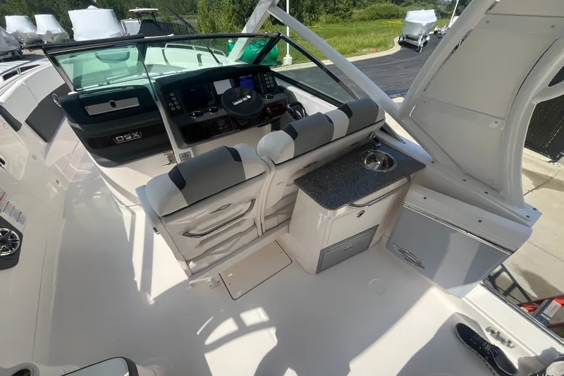 Slide: The Image of 2023 Chaparral 280 OSX boat interior with helm, seating, and kitchenette area. - 16