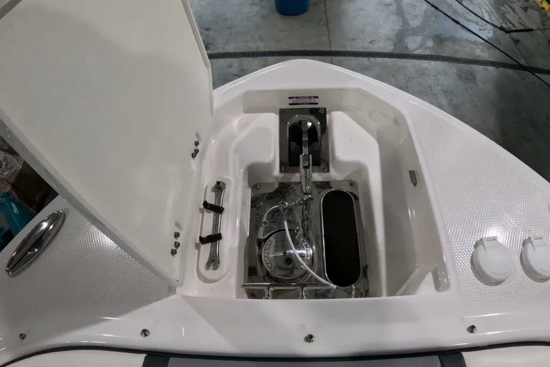 Slide: The Image of 2023 Chaparral 280 OSX boat anchor compartment with open hatch, showcasing storage and equipment. - 21