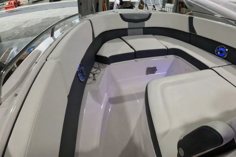 Slide: The Image of 2023 Chaparral 280 OSX boat interior with cushioned seating and blue LED speakers. - 3