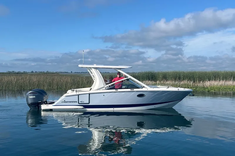 The Image of 2023 Chaparral 280 OSX boat cruising on calm water with clear skies. - 0