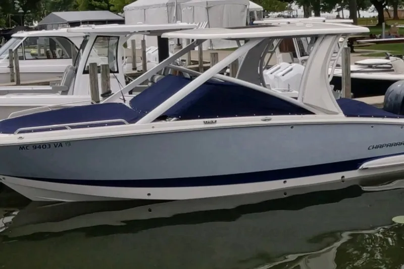 Slide: The Image of 2023 Chaparral 280 OSX boat docked at marina, featuring sleek design and modern amenities. - 2