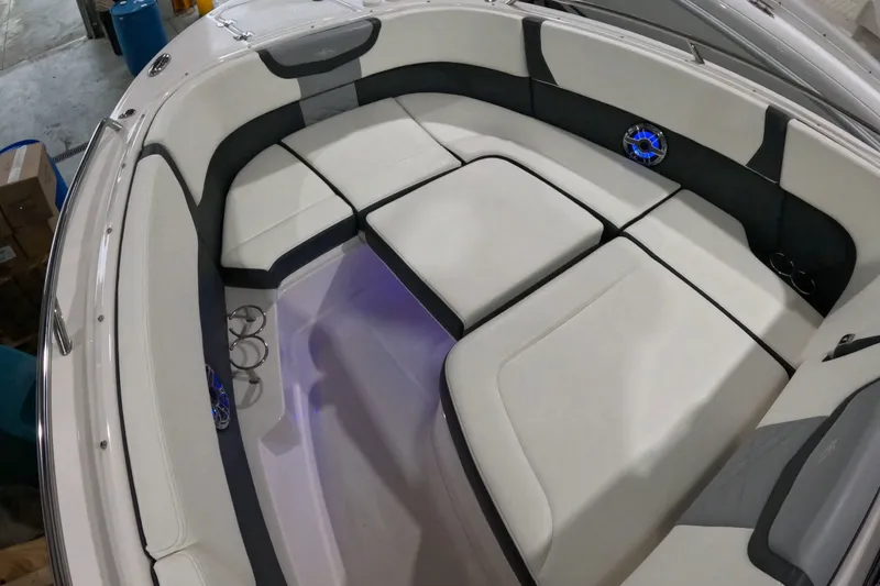 Slide: The Image of 2023 Chaparral 280 OSX boat interior with cushioned seating and blue LED lighting. - 8