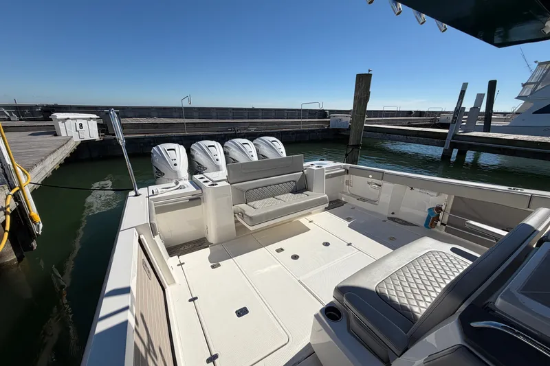 Slide: The Image of 2023 Pursuit S 428 Sport boat docked, featuring spacious seating and four powerful engines. - 13