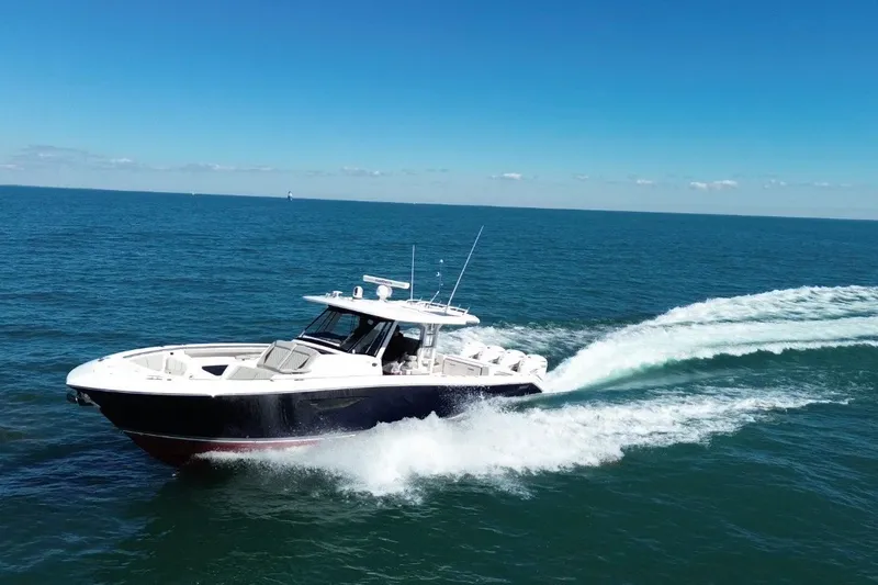 Slide: The Image of 2023 Pursuit S 428 Sport boat cruising on open ocean under clear blue sky. - 1