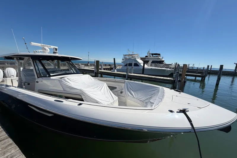 Slide: The Image of 2023 Pursuit S 428 Sport boat docked at marina under clear blue sky. - 35